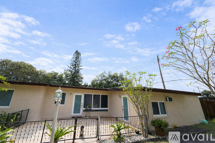 A house with a fence and a tree in the background.