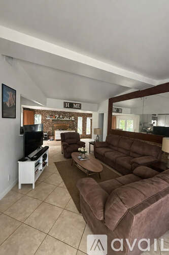 A living room with a brown couch and a flat screen TV.
