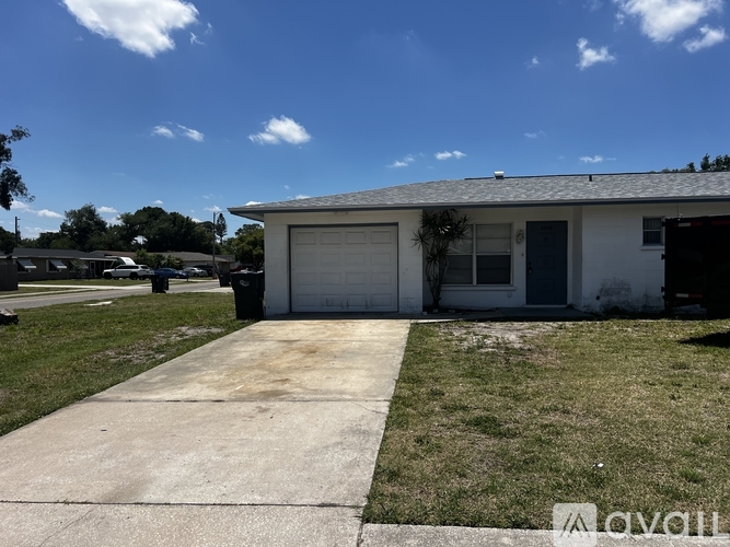 A house with a white garage door and a grey roof.