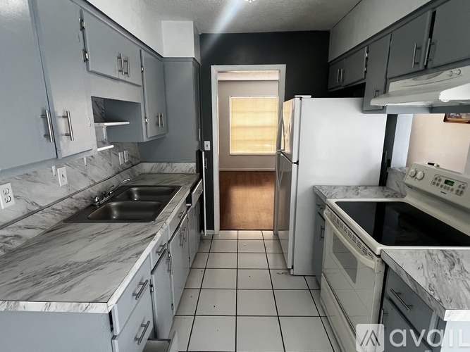 A kitchen with a marble countertop and stainless steel appliances.