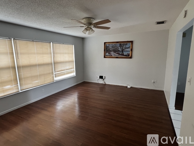 A room with wooden flooring and a ceiling fan.