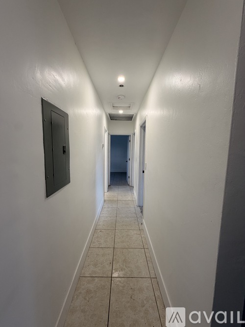 A long hallway with a door on the left and a door on the right.