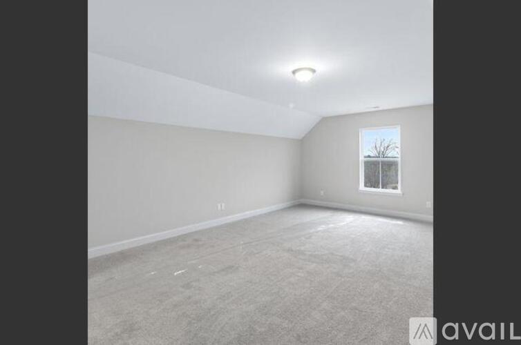 A spacious empty room with a window on the right side.