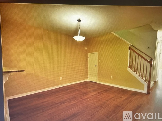A room with wooden floors and a staircase.