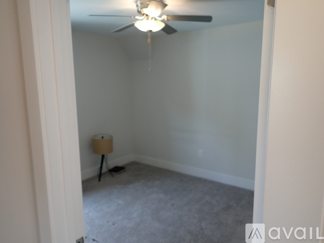 A room with a ceiling fan and a floor lamp.