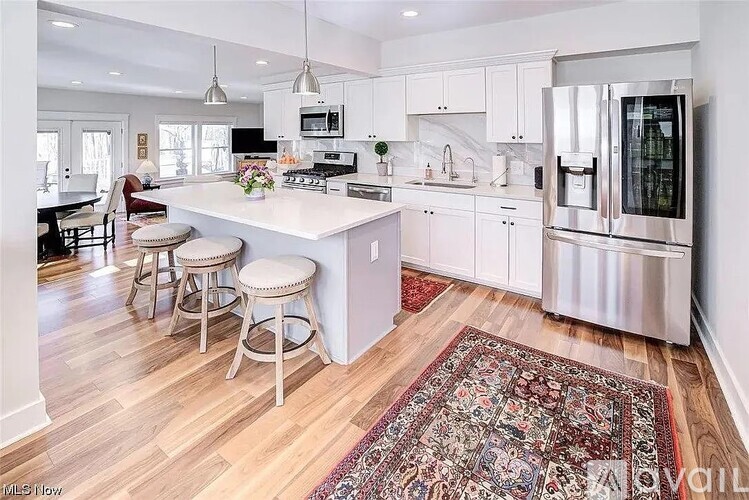 A kitchen with white cabinets and a large island.
