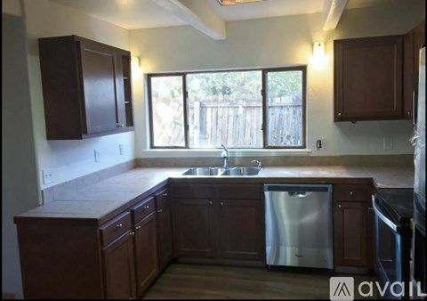 A kitchen with wooden cabinets and a stainless steel dishwasher.