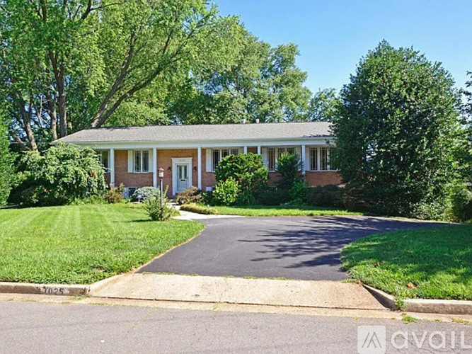 A house with a driveway and trees in the background.