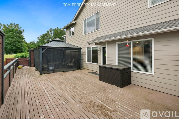 A wooden deck with a black screened area and a gazebo.