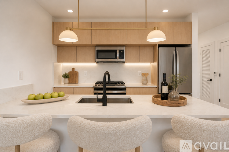 A modern kitchen with a white countertop and a black faucet.