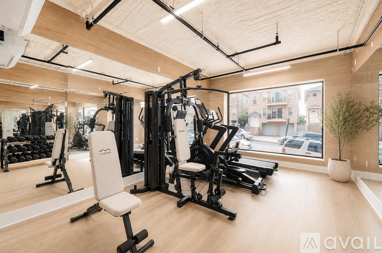 A gym with a variety of equipment including treadmills, weights, and a rowing machine.