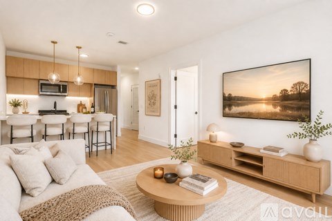 A modern living room with a large painting on the wall and a coffee table in the center.