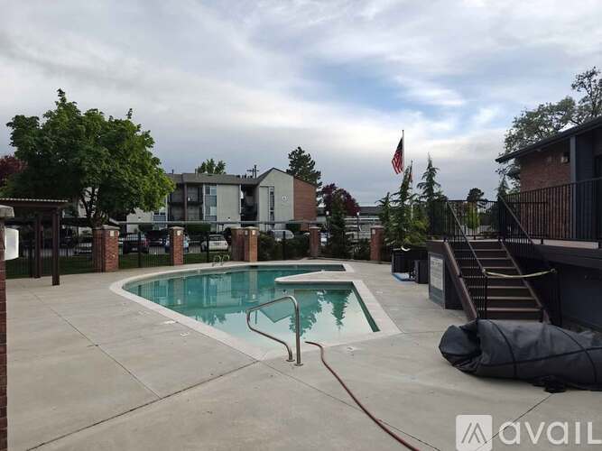 A pool surrounded by a fence and a flag in the background.