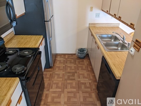 A kitchen with a black stove top oven and a black refrigerator.