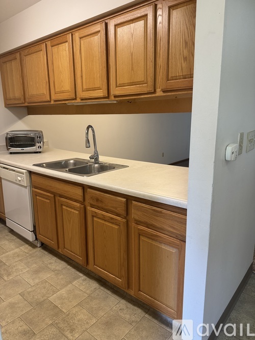 A kitchen with wooden cabinets and a white countertop.