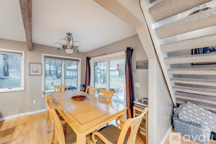 A dining room with a wooden table and chairs.