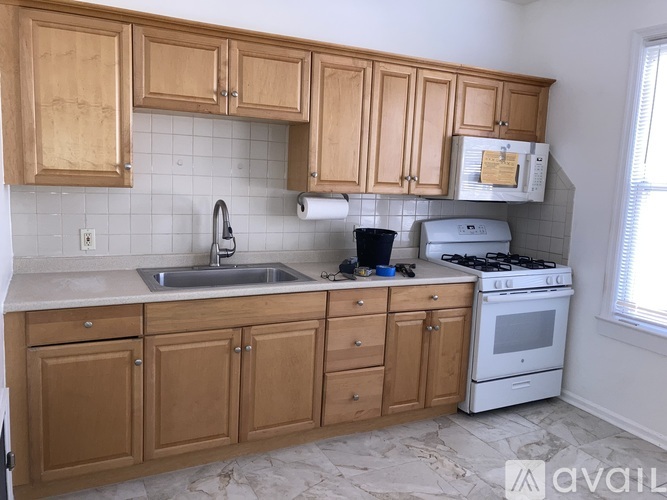 A kitchen with wooden cabinets and a white stove.