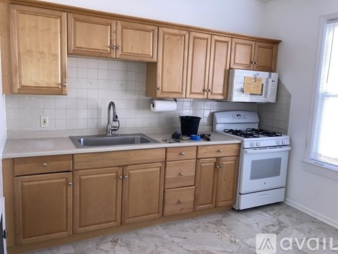 A kitchen with wooden cabinets and a white stove.