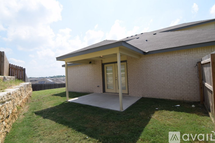 A house with a brown brick exterior and a grey roof with a glass door and window.