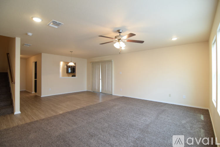 A spacious room with a ceiling fan and carpeted floor.