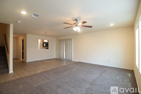 A spacious room with a ceiling fan and carpeted floor.