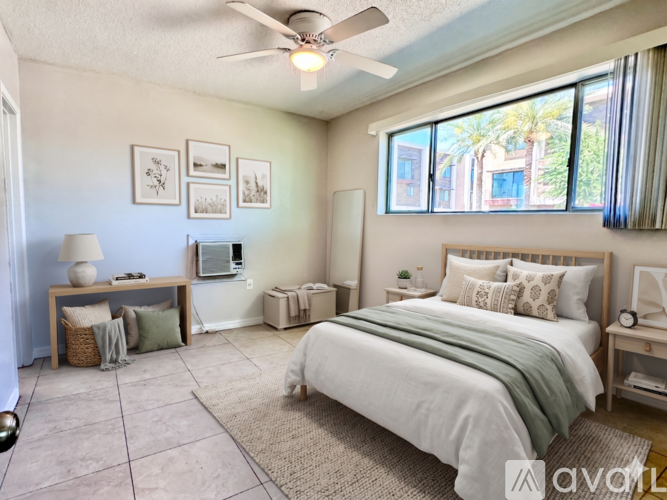 A bedroom with a large bed and a ceiling fan.