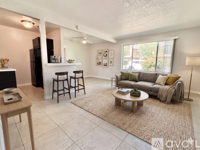 A living room with a couch, a coffee table, and a bar area.