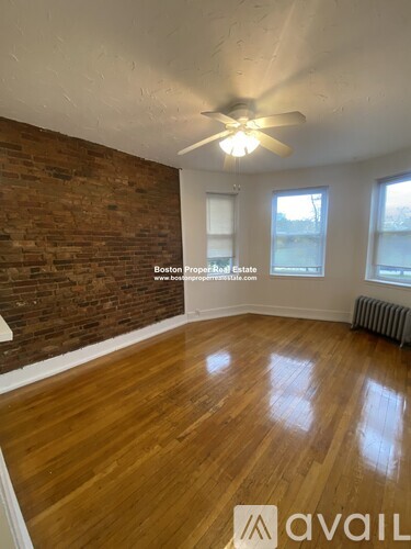 A room with wooden floors and a brick wall.