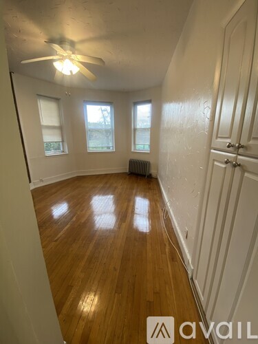 A room with wooden floors and a ceiling fan.
