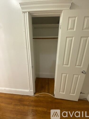 A white door is open to a small, empty room.