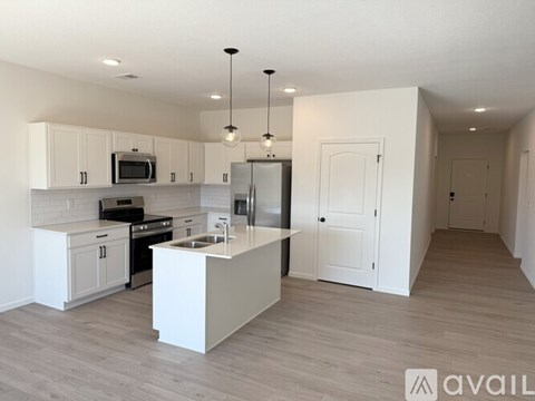 A modern kitchen with white cabinets and appliances.