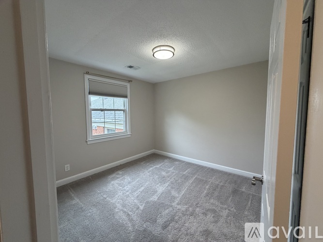 A room with a carpeted floor and a window.