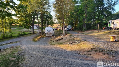 A gravel path leads to a camping area with RVs and a picnic table.