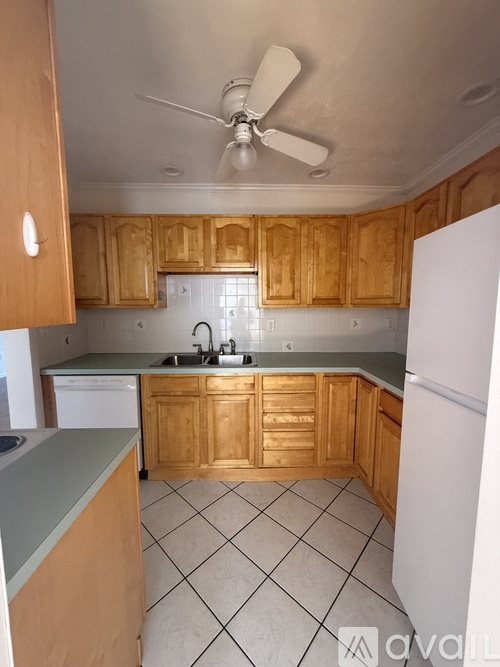 A kitchen with wooden cabinets and a white refrigerator.