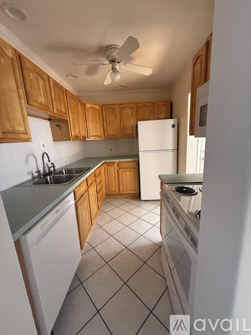 A kitchen with wooden cabinets and white appliances.