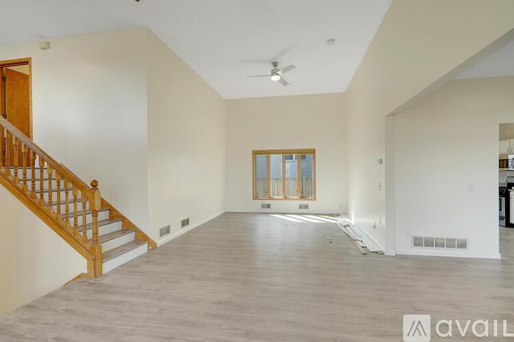 A spacious room with a staircase and a window.