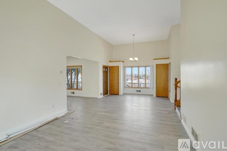 A spacious room with wooden floors and a large window.