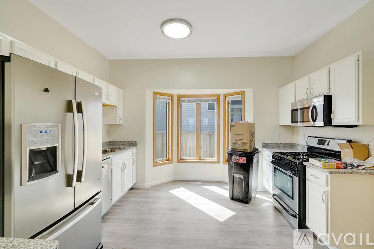 A kitchen with white appliances and cabinets is available for rent.