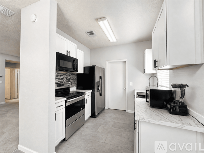 A kitchen with white cabinets and appliances.