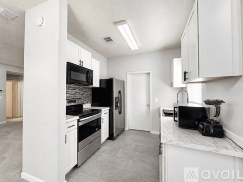 A kitchen with white cabinets and appliances.