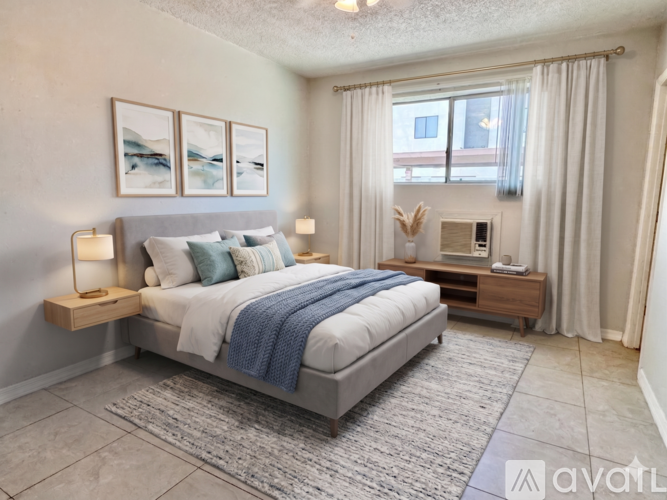 A bedroom with a large bed, a nightstand, and a window with curtains.