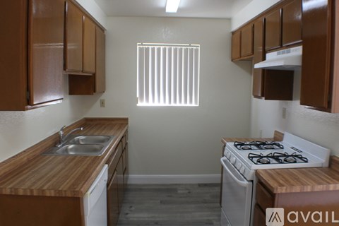 A kitchen with wooden cabinets and a white stove top oven.