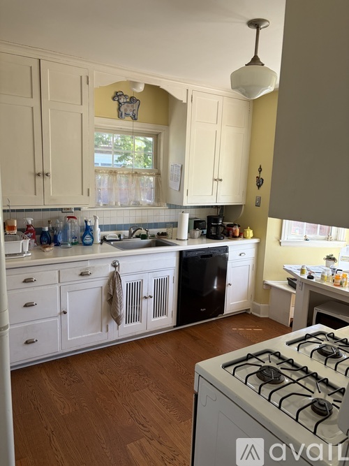 A kitchen with a white stove and white cabinets.