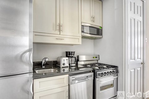 A kitchen with white cabinets and stainless steel appliances.
