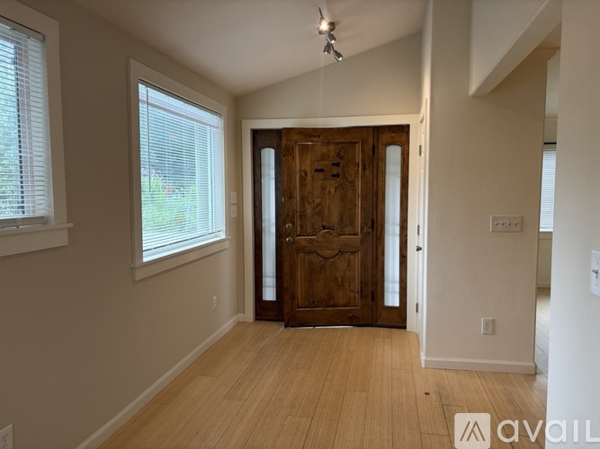 A room with a wooden door and a window with blinds.