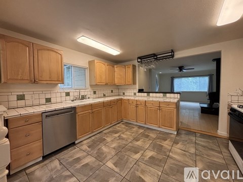 A kitchen with wooden cabinets and a tiled floor.