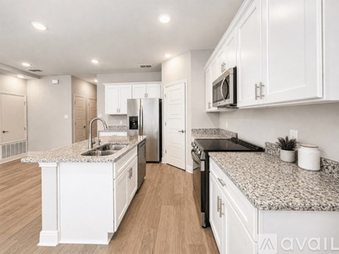 A kitchen with white cabinets and granite countertops.