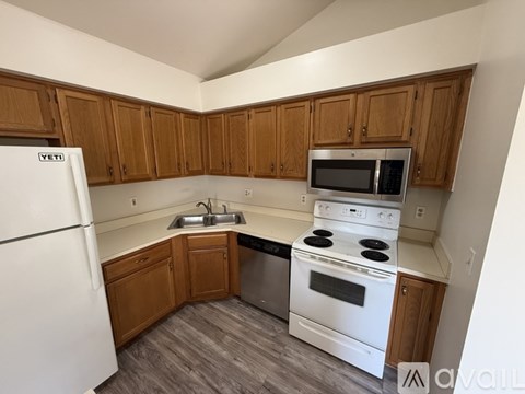 A kitchen with wooden cabinets and white appliances.
