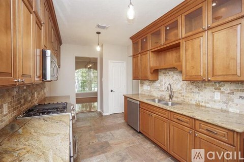 A kitchen with wooden cabinets and a stone backsplash.