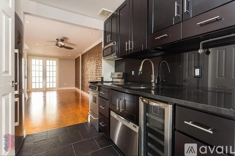 A modern kitchen with dark wood cabinets and stainless steel appliances.